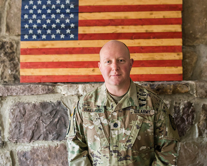 Attorney Jason Ballard In US Army Uniform In Front Of US Flag
